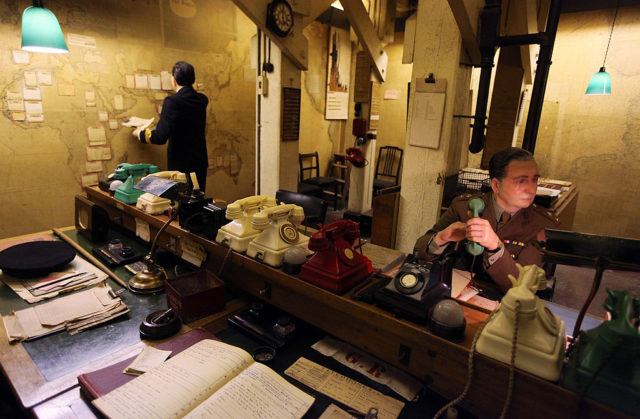 Wax figures in a room filled with telephones