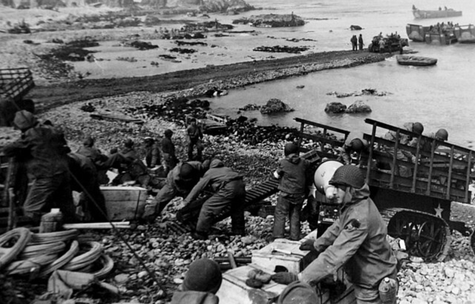 Allied troops standing on the beach at Kiska Island with supplies