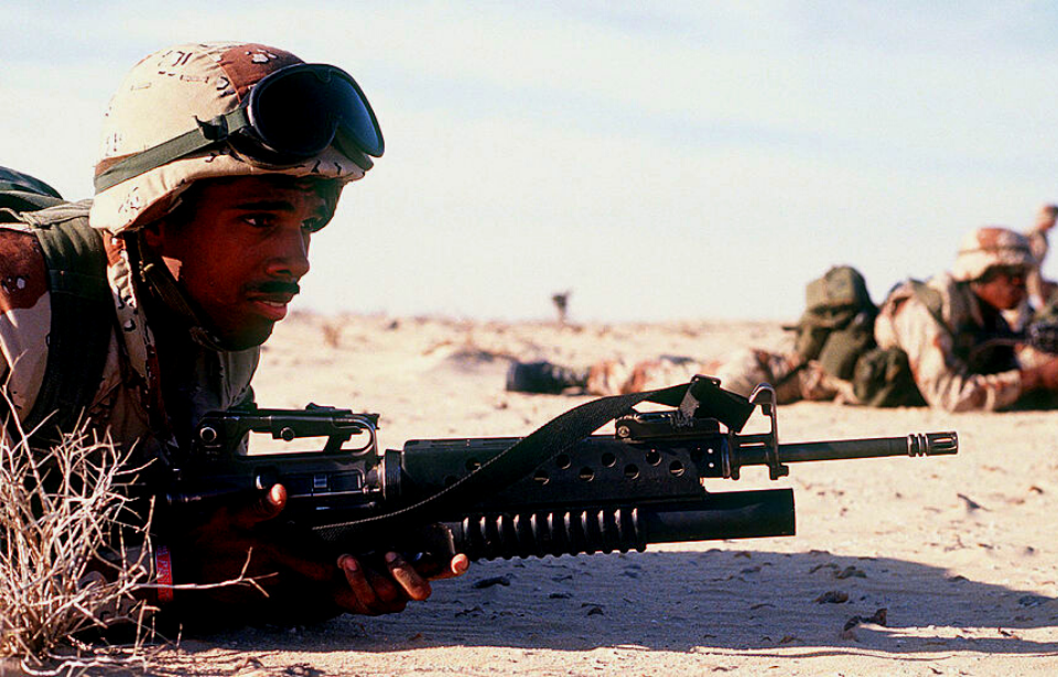 US soldier lying on his stomach with an M16A2 rifle equipped with an M203 grenade launcher