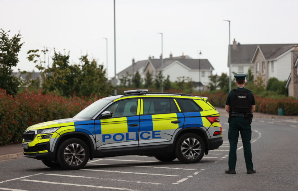 Police officer and vehicle positioned in the middle of a roadway