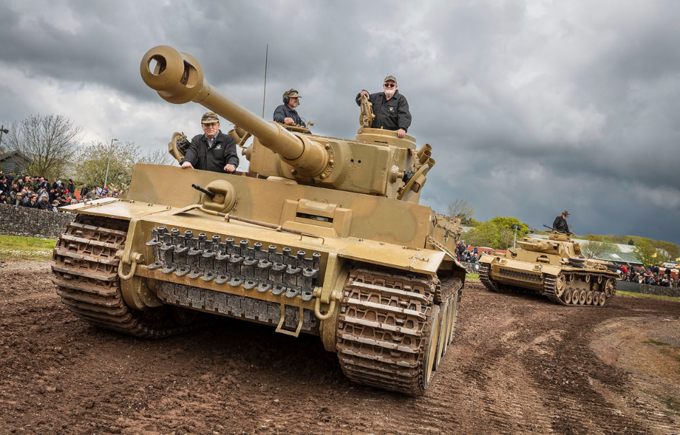 Three men manning Tiger 131 along a dirt track