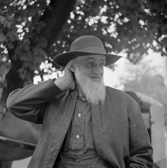 Amish man rubbing the back of his neck