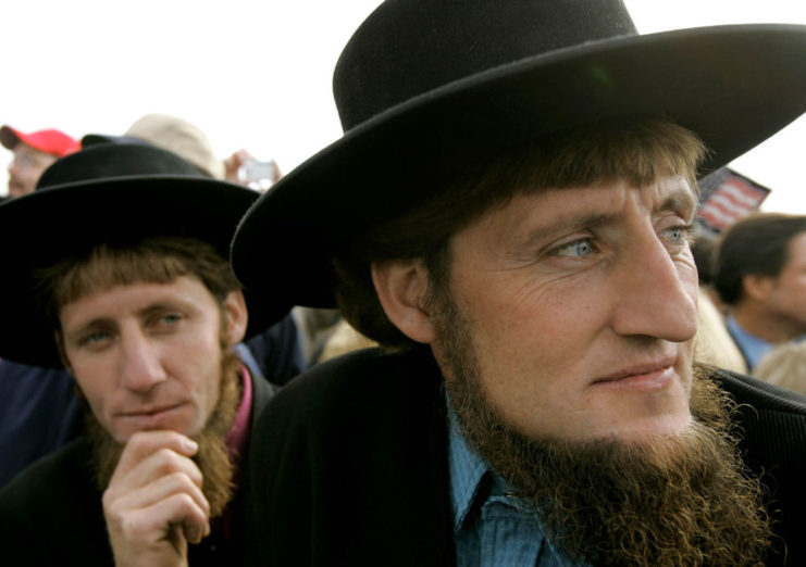 Two Amish men standing among a crowd of George W. Bush supporters