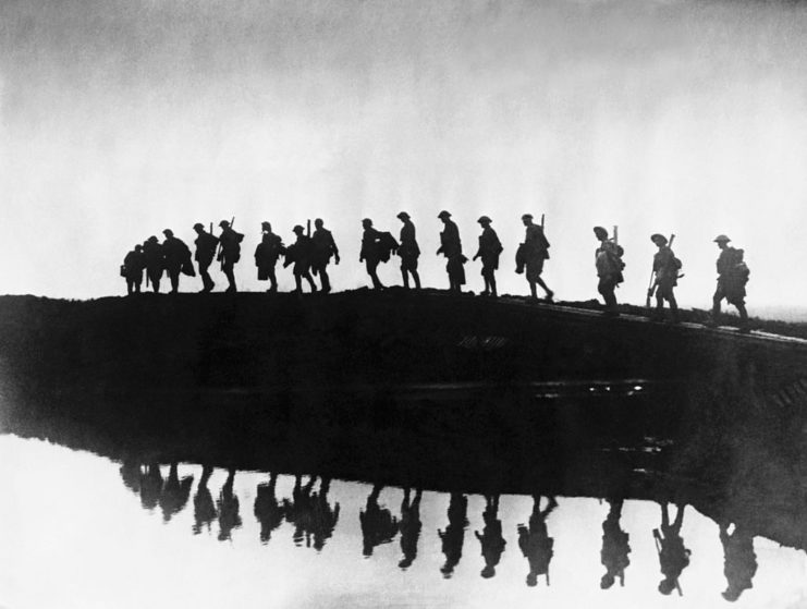 British troops pass a rainwater filled shell crater near the Western Front 