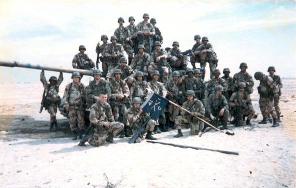 Members of Task Force 1-41 Infantry standing with a captured Iraqi flag