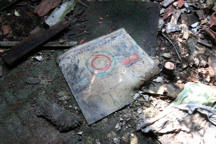 Faded document half-covered by debris on the ground