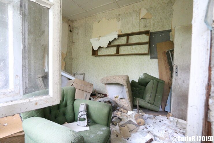 Overturned furniture in the middle of a room filled with debris