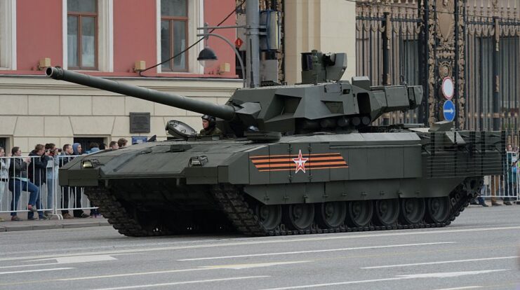 Civilians watching a T-14 Armata driving down a city road