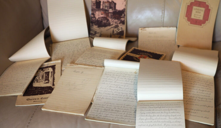 Table covered in hand-written notebooks