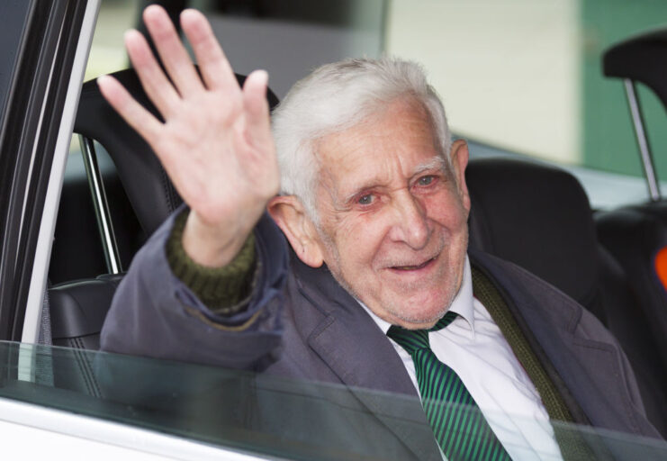 Bernard Jordan waving from the backseat of a vehicle