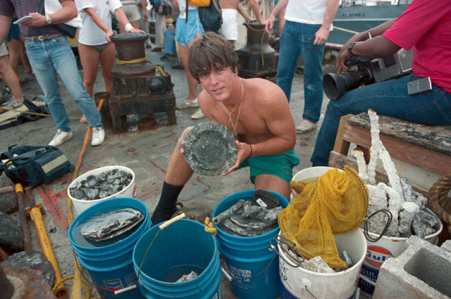 Man holding a corroded plate